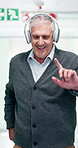 Senior, man and headphones in hospital corridor for dancing, tumor remission or treatment success. Retirement, happy person and audio tech with rhythm, cancer free and spin for clinic discharge news