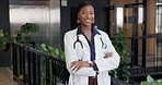 Face, happy woman and doctor with confidence, healthcare and wellness service at eco friendly clinic. Medical trust, smile and black person at green hospital, arms folded and portrait of professional