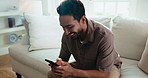 Texting, laugh and man on couch with phone, online communication and social media scroll on day off. Digital, happy and person in house with tech, message notification and chatting on weekend break.
