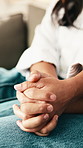 Home, holding hands and couple on couch with relax, love and care for bonding and marriage. People, man and woman together with relationship, comfort or trust with romance and support in living room