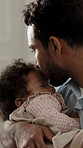 Care, kiss and father with sleeping baby in home for rest, development support or bonding together. Love, parent and rocking infant child for nap with calm, growth or dream with peace in family house