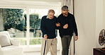 Caregiver, help and old person with cane in home for support, assistance or physical therapy. Man, senior patient with a disability and mobility aid in assisted living facility for physio or recovery