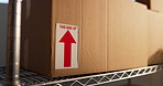 Shelf, boxes and logistics in warehouse with label for shipping, supply chain or ecommerce safety. Cardboard, package sticker and storage unit, distribution and arrow for fragile goods protection