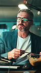 Night, man and eating in workplace with computer, internet and SEO trend research in office. Mature person, food and tech for review online website traffic, search engine best practices and deadline