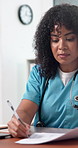 Doctor, laptop and writing in hospital with documents, research and health insurance administration. Woman, browse or taking notes in clinic with checklist, medical aid or computer for typing report.