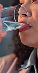 Thirsty, businesswoman and drinking water in office with glass, wellness and hydration on work break. Employee, person and healthy nutrition in workplace with H2O, refreshing liquid and beverage.