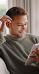 Reading, online and happy man with tablet in lounge, laughing and communication with contact on web. Typing, message and person with smile in living room, relax and funny chat with technology in home