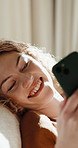 Texting, online and happy woman with phone in lounge, laughing or communication with contact on web. Reading, message and person with smile in living room, relax and funny chat with mobile in home