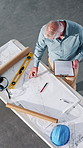 Architecture, above and man with blueprint, clipboard and paperwork for building, design and layout. Construction, contractor and mature person with report, sketch and remodeling plan for renovation