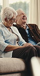 Senior, laughing and happy couple on sofa in home for funny joke, humor or playful bonding together. Elderly, man and woman with smile, tablet or comedy for movie or online entertainment in house