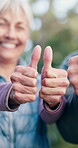 People, hands and health with thumbs up for outdoor fitness, good review or teamwork together. Happy, senior group or retirement with smile, like emoji or yes sign for wellness, feedback or unity