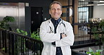 Face, man and doctor with smile, confidence and wellness service at healthcare hospital. Medical trust, happy or mature person at lobby, about us or portrait of general practitioner with arms crossed