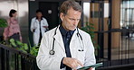 Doctor, medical and scroll with tablet in clinic for patient records, admin work or reading email. Tech, mature man and serious healthcare worker in lobby with assessment report, update or research