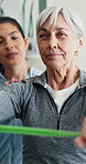 Senior, woman and stretch with resistance band for physio, injury recovery or guided breathing. Clinic, worker and old person with equipment for physical therapy, posture correction or rehabilitation