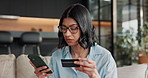 Credit card, phone and woman on sofa for online shopping, ecommerce payment and digital banking. Typing, home and person on mobile app with debit info for subscription, purchase and website store
