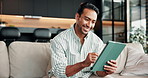 Smile, man and relax on couch with tablet, streaming and watching trailer of new movie releases. Happy, male person and typing at house with tech, upcoming film and internet search for trending video