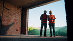 Back, people and talk with engineer at construction site for inspection, planning and architecture. Men, team or pointing for quality assurance, property development and discussion on urban expansion