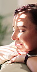 Happy, sunlight and woman on sofa for thinking, reflection and memory for good mood on weekend. Smile, home and person with inspiration, thoughtful and wondering for positive mindset, peace and relax