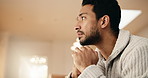 Anxiety, thinking and man on sofa in home for stress, trauma and mental health in living room. Nervous, uncertain and person with stimming for phobia, panic attack or pressure for bad news in house.