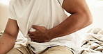 Hands, person and stomach ache in home, sick or uncomfortable with irritable bowel syndrome. Health risk, abdomen pain or man with constipation, gas bloating or diarrhea problem with food poisoning