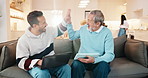 Senior, dad and adult son with high five in home for asset management, financial success or help. Elderly, father and man with laptop, tablet or lens flare on sofa for teamwork together in house