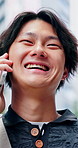 Laugh, conversation and Asian man in city with phone call, travel outdoor and listen to funny story. Low angle, happy person and tech downtown with contact, joke communication and commute in Japan.