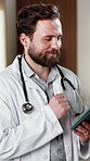 Healthcare, doctor and man with tablet in clinic, smile and review test results on app and thinking. Hospital, medical professional and happy person with tech, reflection and reading health report