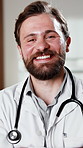 Face, doctor and healthcare with smile at hospital, medical professional and integrity with surgeon. Man, physician or surgical specialist with ambition, pride and happiness for expert in medicine