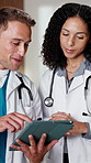 Doctors, people and discussion with tablet in clinic for research, digital app or test results. Man, woman and medical service in hospital with tech, decision and healthcare schedule conversation