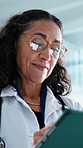Doctor, glasses and woman with tablet in hospital, research or reading healthcare report on website. Clinic, medical professional and mature person with technology, scroll and treatment plan on app