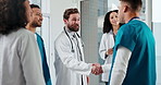 People, doctor and meeting with handshake in hospital for medical agreement or procedure together. Happy man, healthcare team or shaking hands with nurse for partnership, deal or discussion in clinic