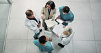 Above, nurse and doctors in hospital with document, patient charts and planning for treatment. People, team and talk in meeting with paperwork, medical records and case study for healthcare services