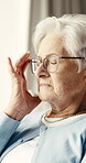Headache, pain and senior woman in home with fatigue, high blood pressure or rest with glasses. Elderly person, migraine and massage temple in house with hypertension, eye strain or retirement stress