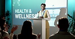 Happy, speaker and applause for woman in seminar, celebration or successful healthcare presentation. People, clapping and talking with audience, health and wellness speech in workshop and convention