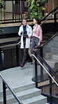 Doctors, team and walk on staircase with tablet, research and medical opinion on test results. People, talking and steps at hospital with digital app, patient case and treatment plan for healthcare