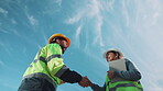 Blue sky, low angle and shaking hands with construction people for inspection, introduction and team. Engineer, partnership or welcome with handshake for evaluation, renovation and tablet outdoor