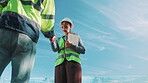 Blue sky, below and handshake with construction people for inspection, introduction and partner. Engineer, team and welcome with shaking hands for evaluation, renovation and tablet in outdoor space