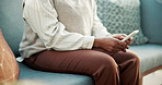 Woman, hands and typing on couch with phone, relax and play game for entertainment on weekend break. Female person, chill and online gaming in home with tech, mobile app and internet connectivity.