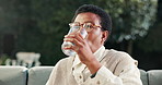 Drinking, water and woman with medicine in backyard, healthcare or prescription supplement at house. Wellness, benefits and mature black person with mineral liquid, treatment and health management