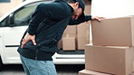 Logistics, delivery or man with back pain, spine issue or labor injury in outdoor distribution. Strain, burnout or courier at van with packages, backache massage or muscle discomfort in supply chain.