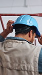 Back, thinking and man with helmet for inspection, construction project and remodeling in building. Contractor, engineer and person with ppe for property evaluation, safety compliance or architecture