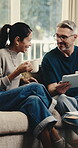 Laugh, coffee and tablet with couple on sofa for booking app, bonding and flight registration. Connection, online holiday discount and funny with mature man and woman in living room in home for drink