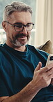 Laugh, phone and man on sofa with connection, online communication and comic post on social media. Happy, digital and mature person in house with browse, funny text and meme reaction on chat app.