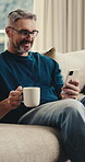 Laugh, phone and man on sofa with coffee, online communication and comic post on social media. Happy, digital and mature person in house with warm drink, funny text and meme reaction on chat app.