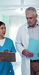 Medical, team and reading in hospital with clipboard, insurance and healthcare results for Telehealth. People, doctor and nurse with folder for collaboration, patient record and opinion for treatment