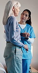 Old woman, caregiver and help on bed with care, assisted living and support in nursing home. Elderly patient, nurse and holding hands in bedroom for friendly service, healthcare and consulting
