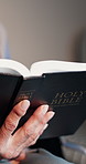 Hands, faith and reading bible for religion, retirement and spiritual scripture in wheelchair. Holy book, christianity and senior person with disability, study theology and gospel guide at home