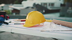 Helmet, blueprint and strategy on construction site for civil engineering or infrastructure upgrade. Hardhat, urban planning and general work PPE for safety, architecture and outdoor workspace