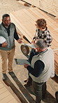 Woodwork, teamwork and conversation in factory above, stock inspection or production schedule. Men, carpenter or planning in meeting with manufacturing clipboard, inventory check or point with tablet