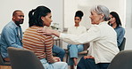 Therapy, group or women in center with support, understanding or empathy in clinic session. Mental health, patient or people with shoulder touch, encouragement or coping together in counseling.